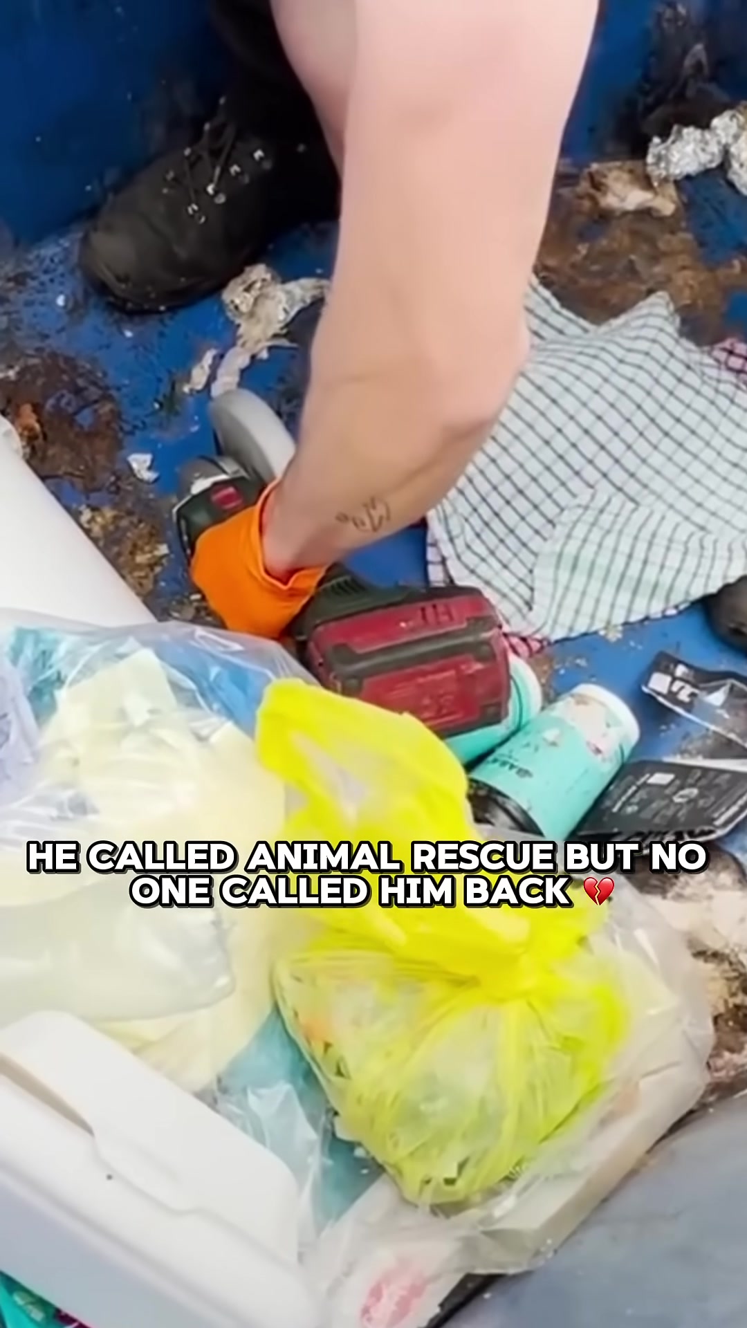The engineer uses a tool to cut through the plastic of the dumpster to free the kitten.