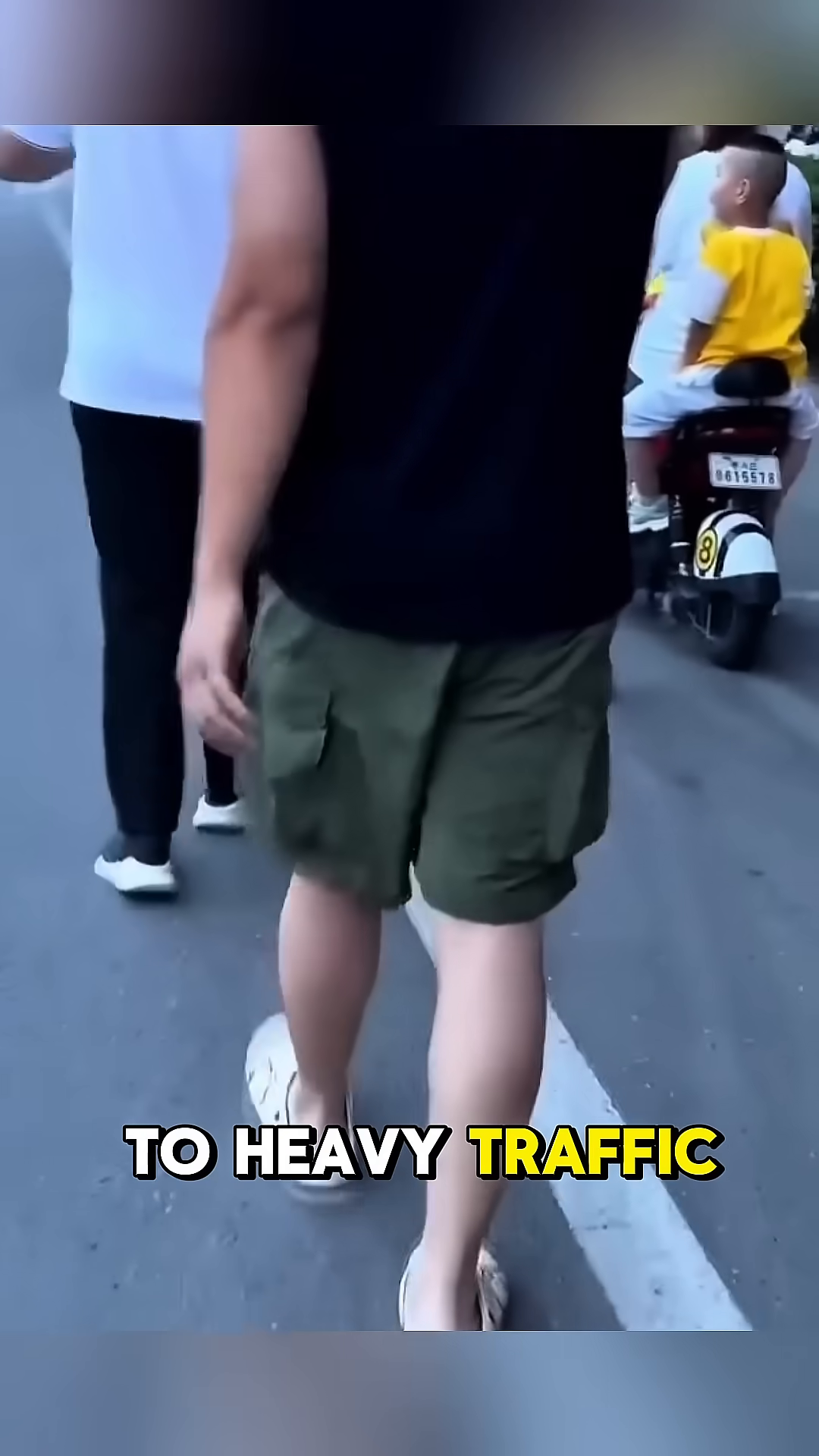 A woman and a young boy on a scooter look towards the scene with concern.