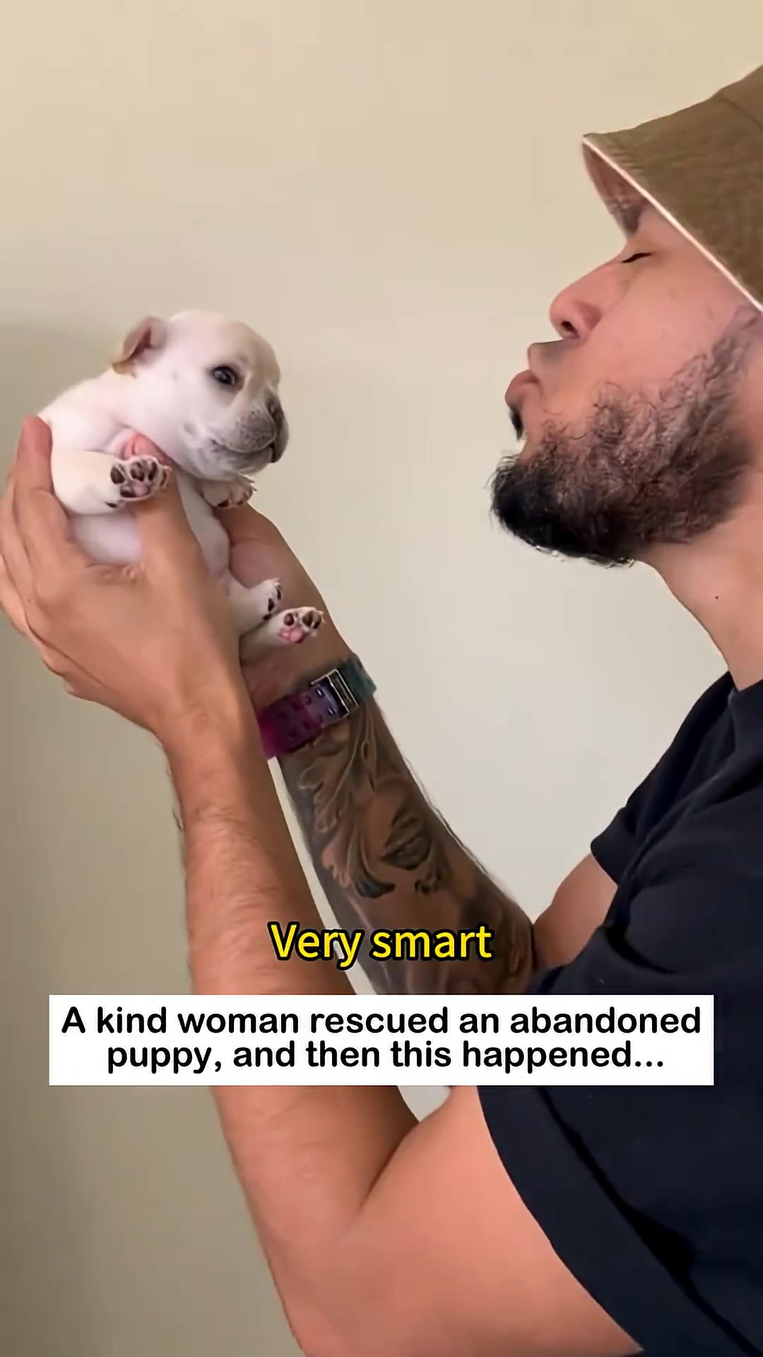 A person holding a small puppy up to their face, about to kiss it.