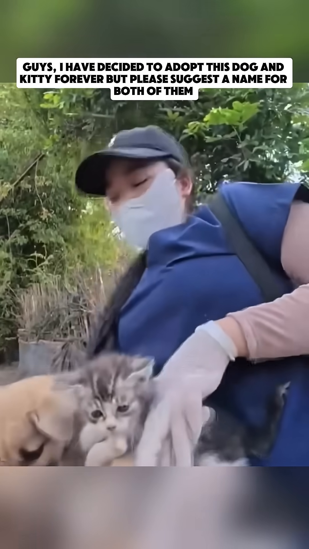 A person holds a dog and kitten together, smiling.