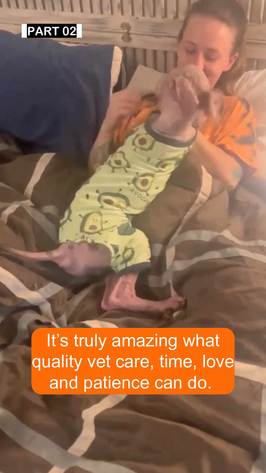 Bentley, now wearing a cute onesie, is being held and comforted by a person.