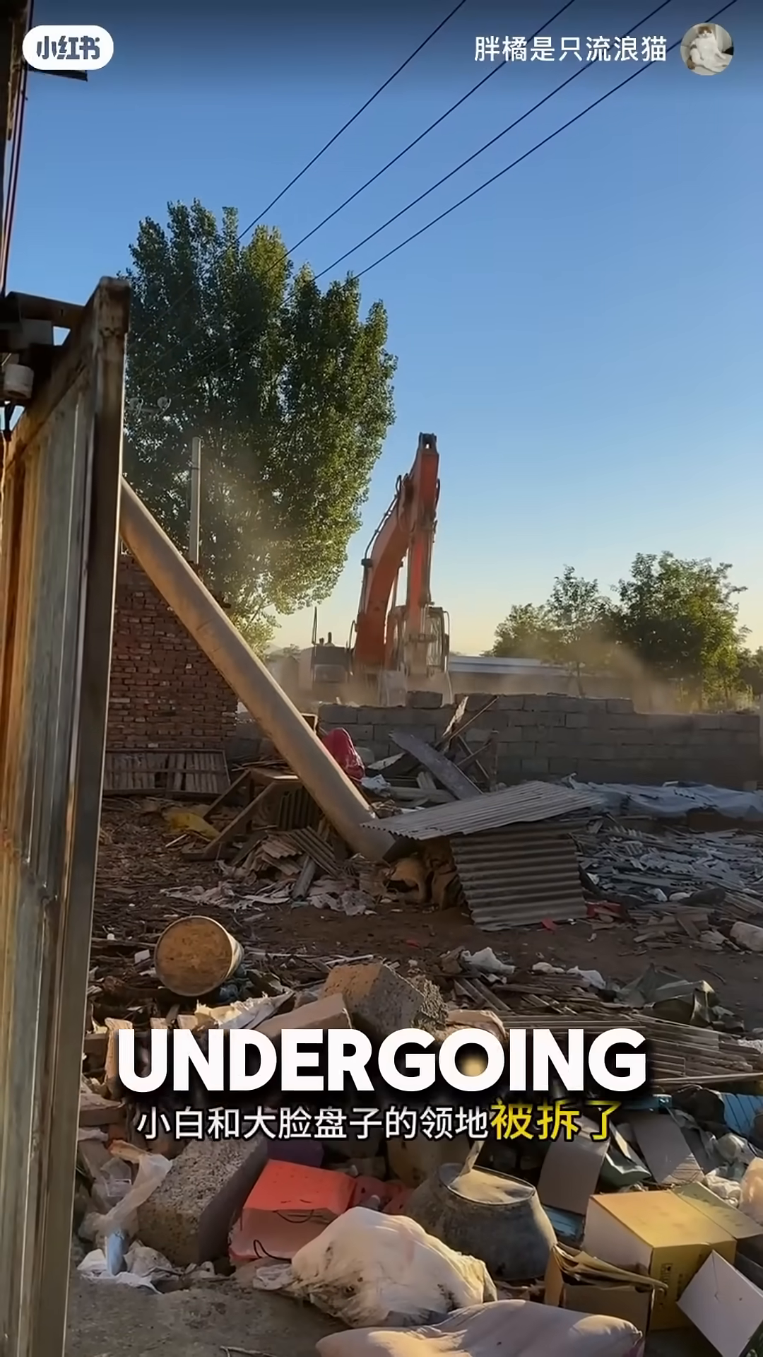 A pile of rubble and debris from a demolished building under a bright blue sky.