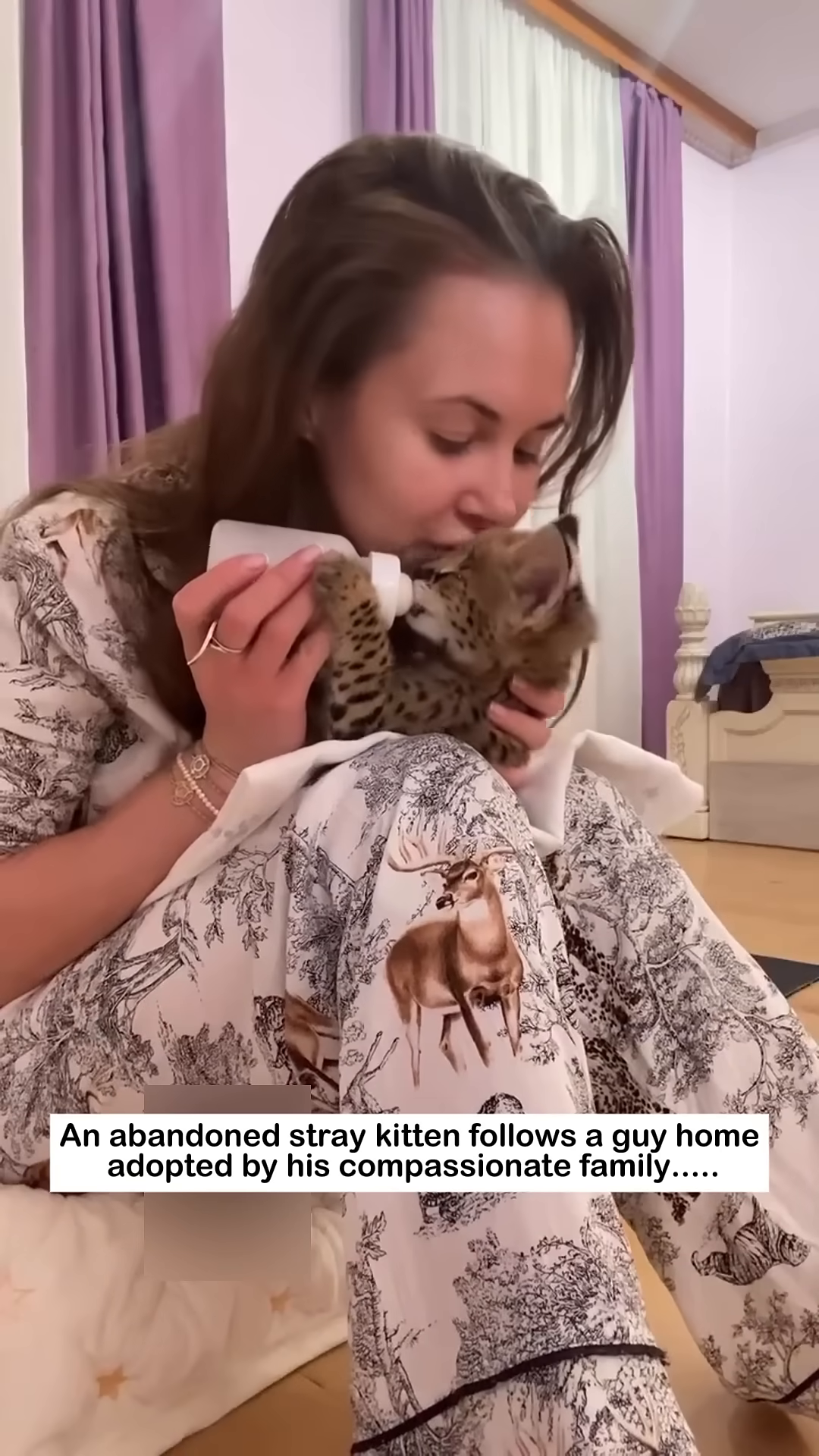 A woman gently feeds a tiny kitten from a bottle, cradling it in her arms.