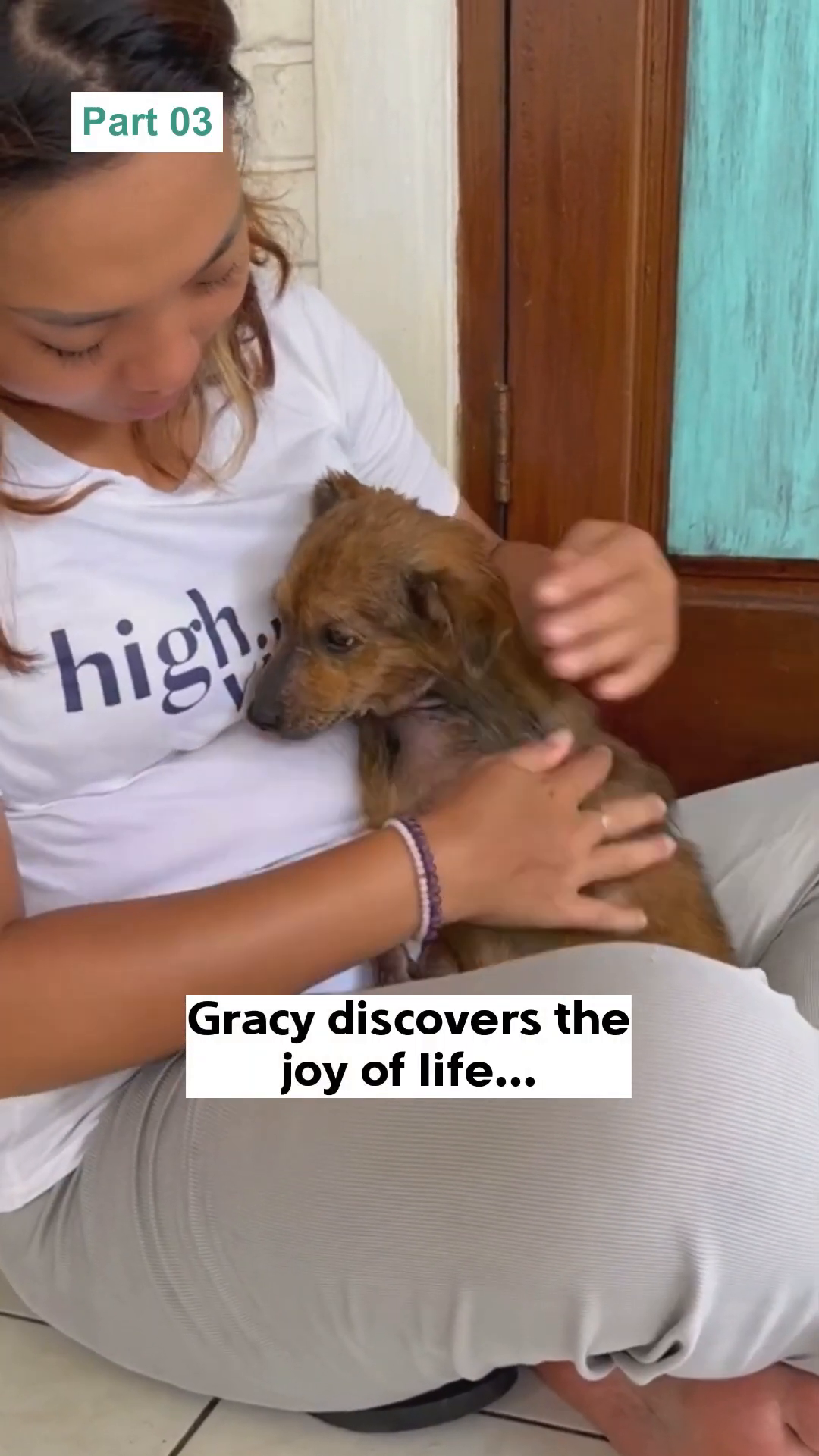 A woman cradles a dog, gently stroking its head, with both looking content.