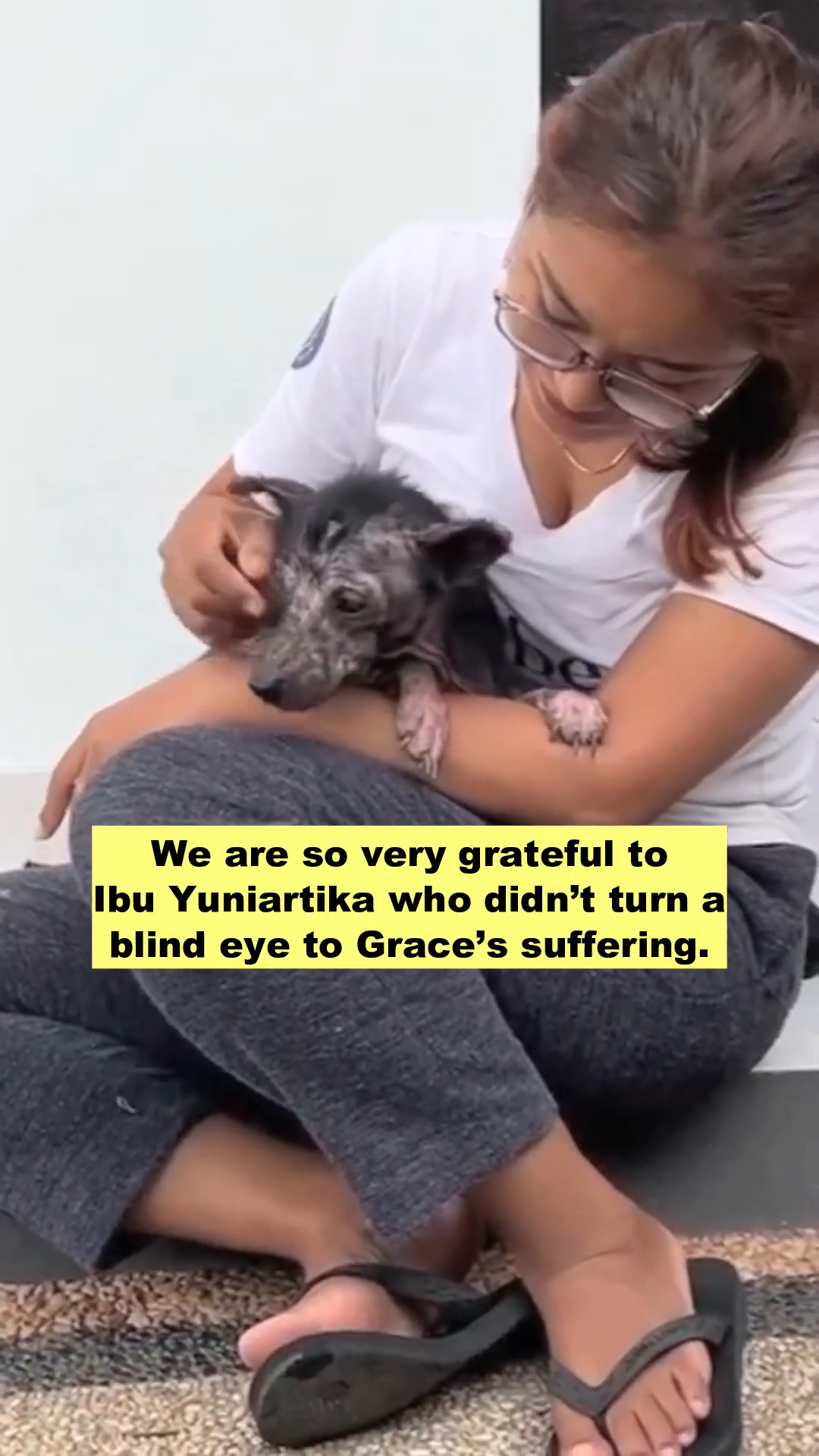A woman gently holding the dog, now named Grace, in her arms, looking loving.