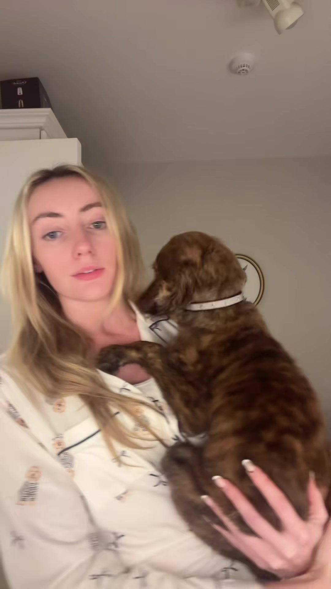 Chloe cradles the brindle puppy against her chest.